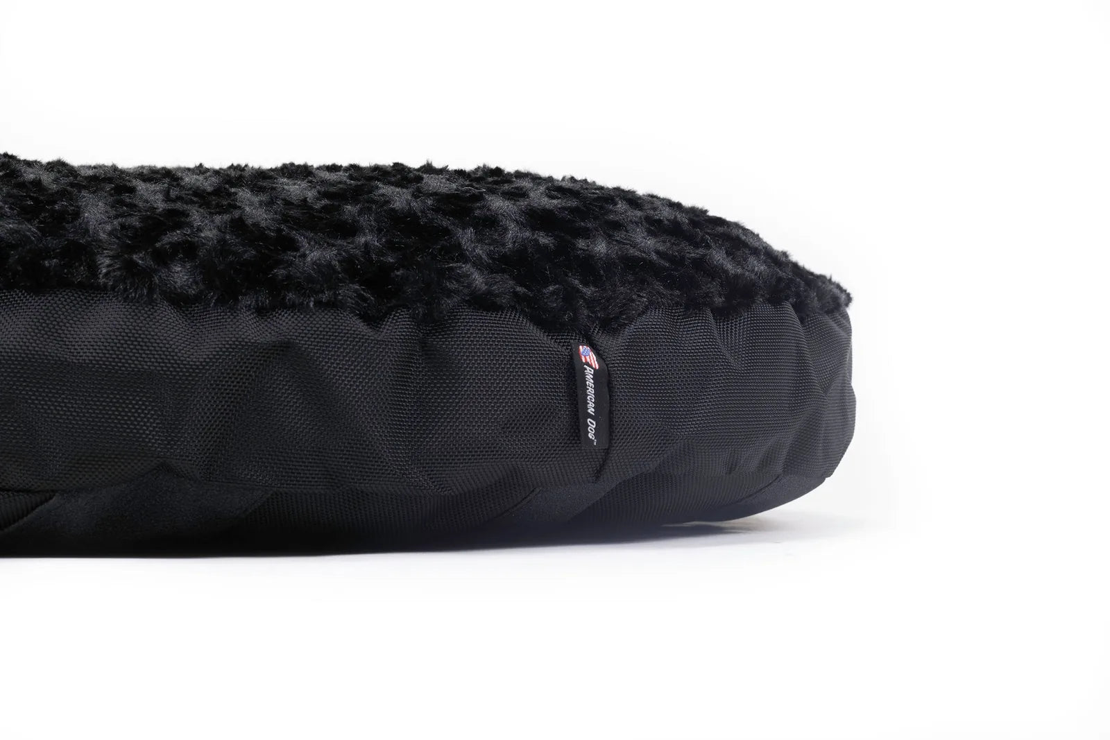 Round Furvana Dog Bed in black featuring a soft faux fur top and durable nylon bottom for superior comfort and stability.