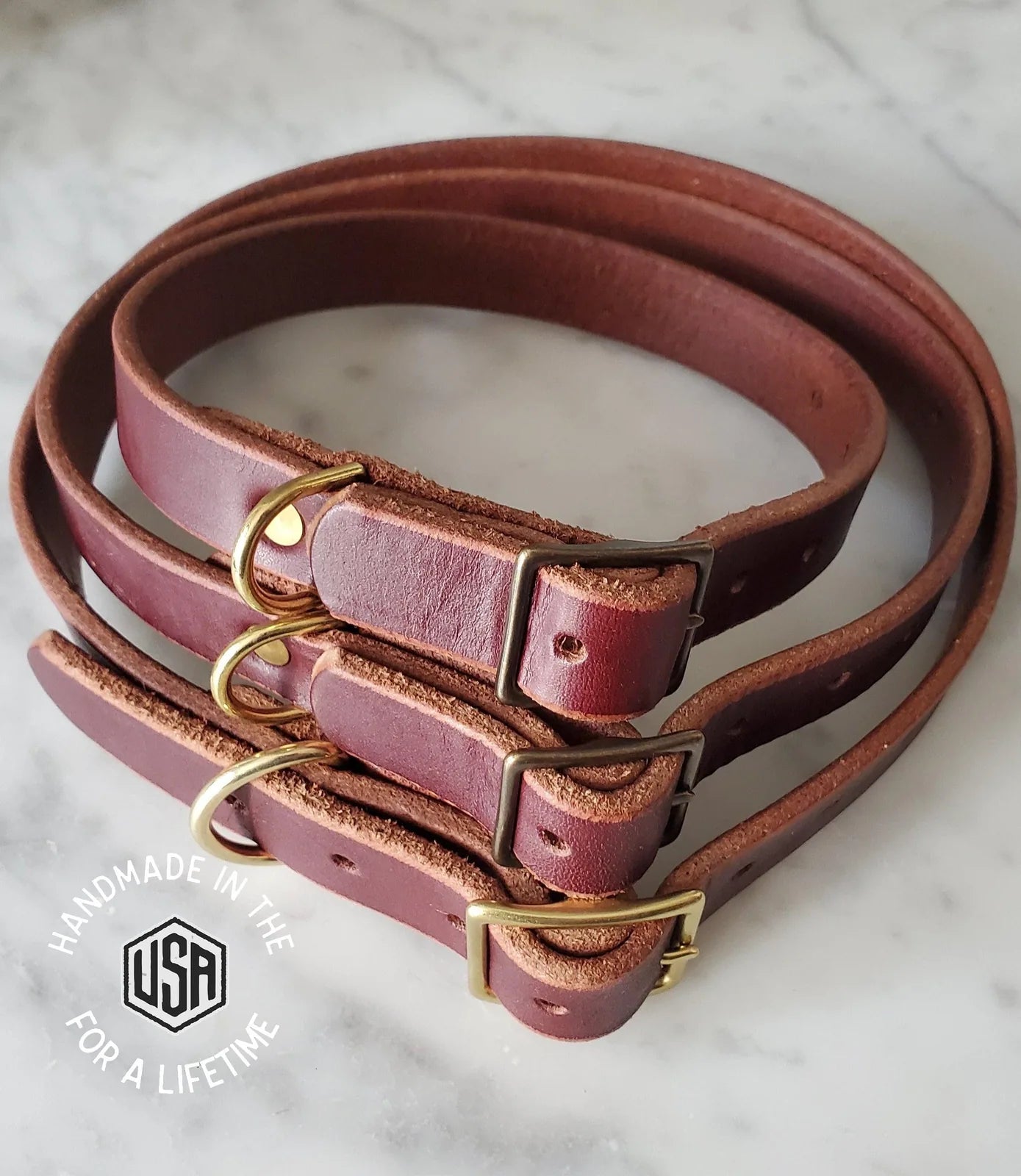 Handcrafted leather dog collars in rich brown with solid brass hardware, showcasing customizable sizing options.