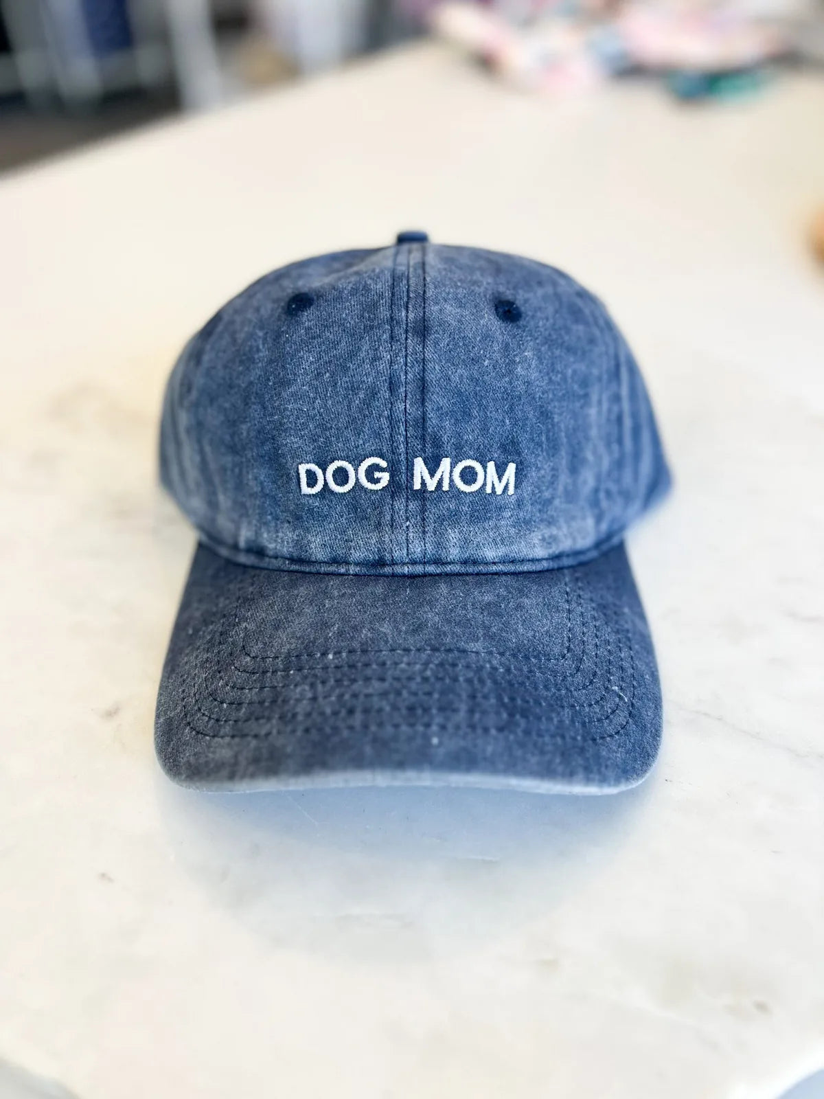Blue vintage-style baseball hat with "DOG MOM" embroidered on the front, made from 100% washed cotton.