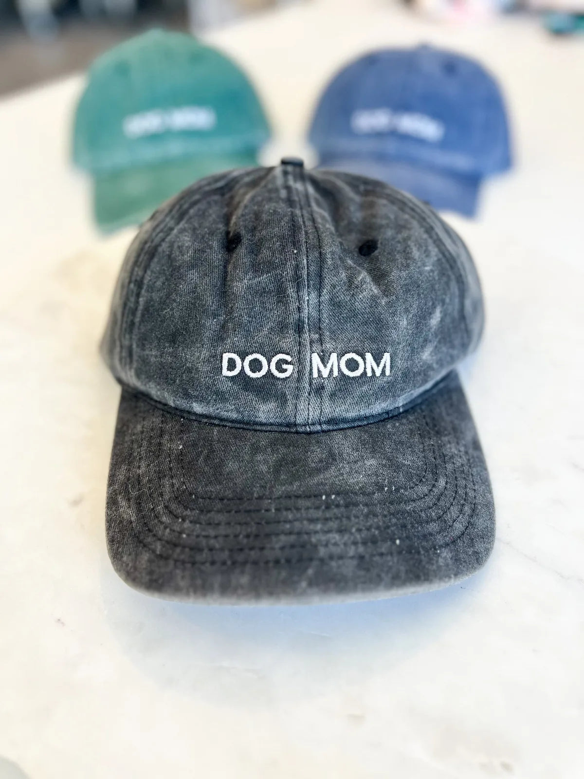 Gray vintage-style baseball cap with "DOG MOM" embroidered, made from 100% washed cotton.