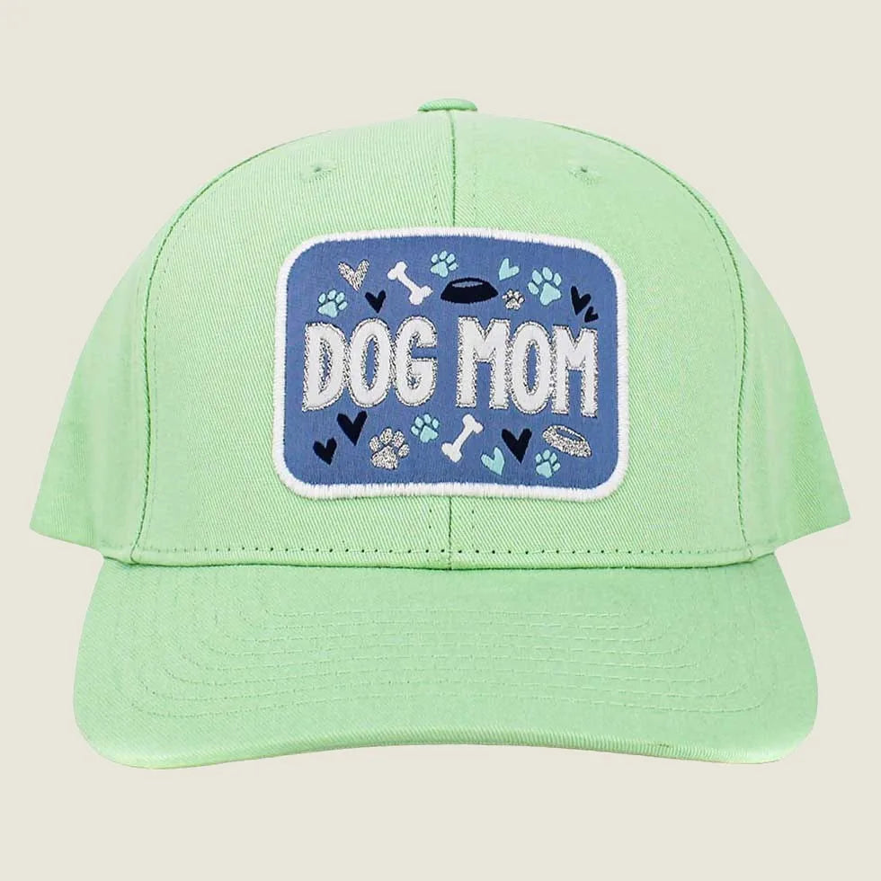 Light mint baseball cap with "DOG MOM" embroidered on a blue patch, featuring playful dog-themed graphics.
