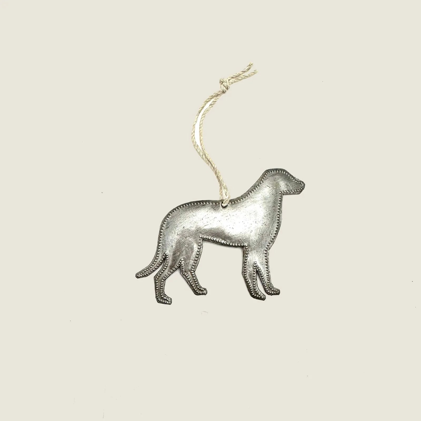 Handcrafted silver dog ornament made from recycled steel, featuring unique detailing and a hanging twine.