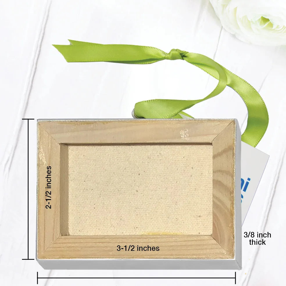 Mini canvas with unfinished beige surface, measuring 2-1/2 by 3-1/2 inches, adorned with a green hanging ribbon.