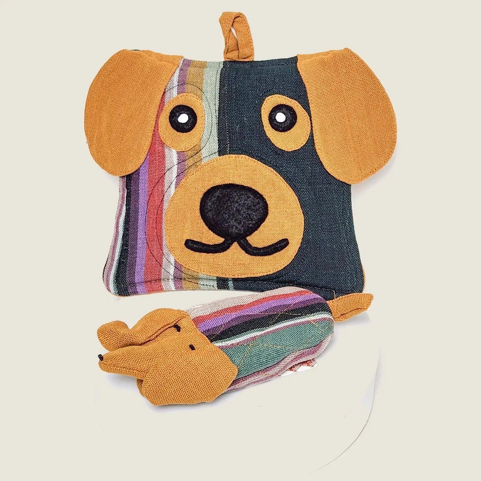 Colorful dog-shaped pot holder with a playful design, featuring stripes and a cute face, made from 100% cotton.