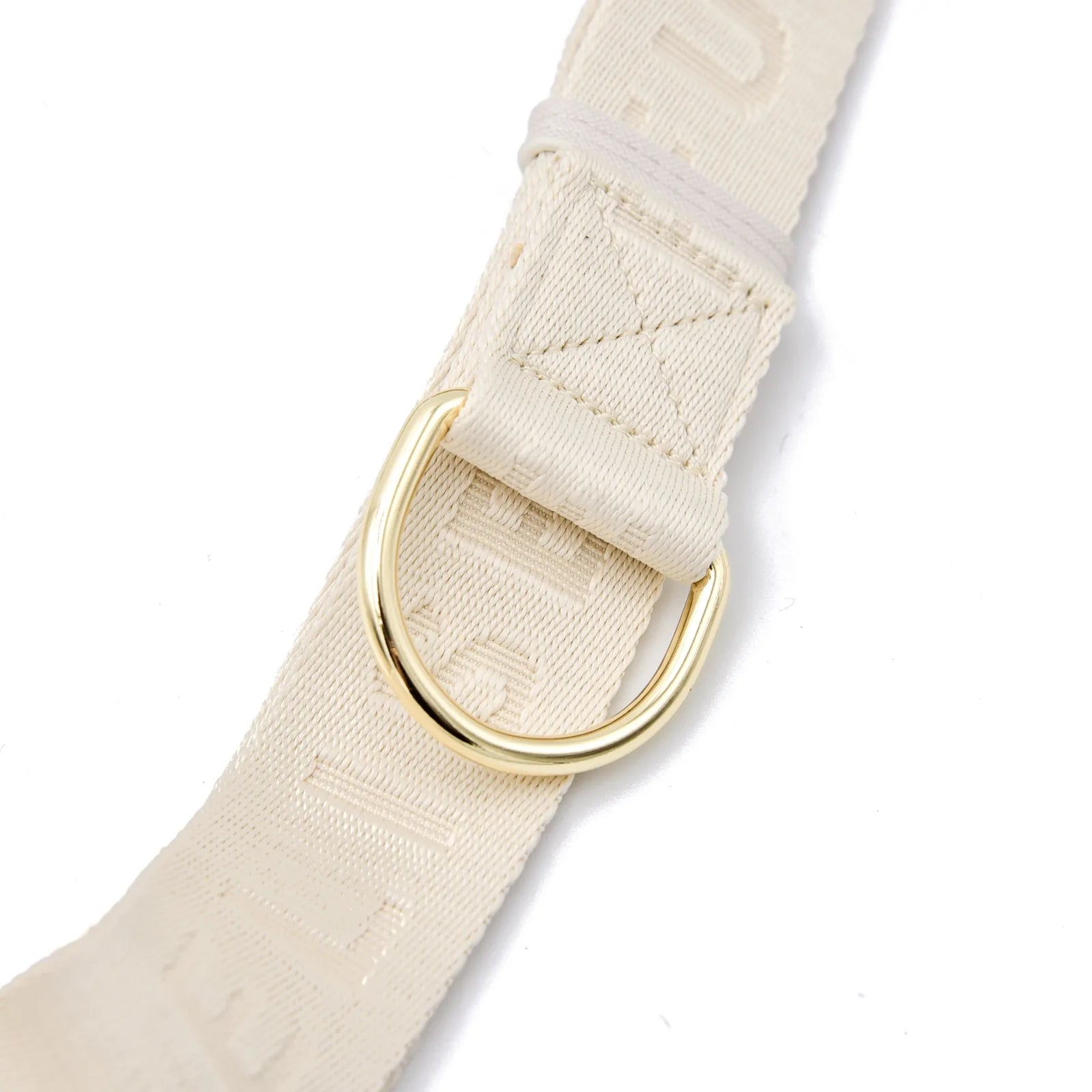 Cream nylon belt with embossed lettering and a gold D-ring for attaching accessories or leashes.