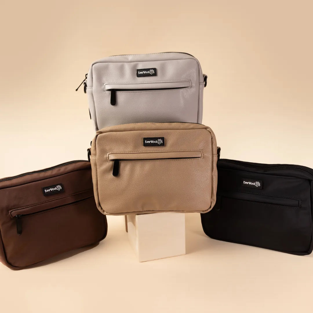 Four EverWoof Doggy Owner Essentials Bags in black, brown, faux leather grey, and nude on a light backdrop.
