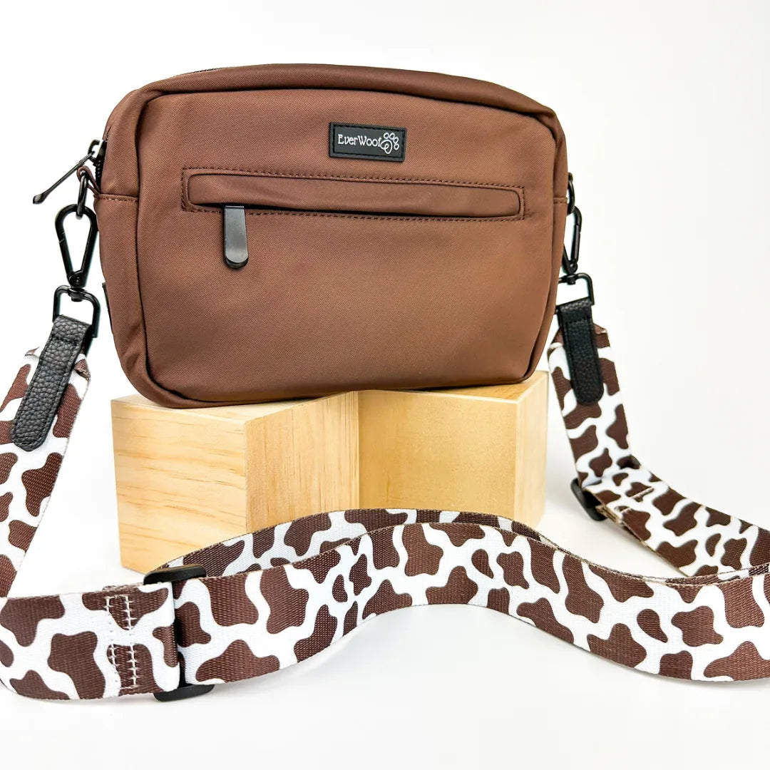 Brown waterproof dog owner essentials bag with a patterned strap, featuring zippers and a sleek design.