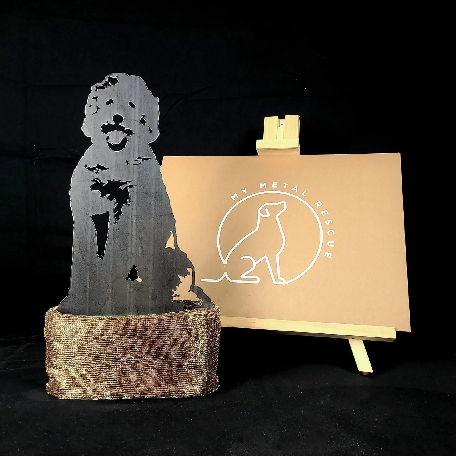 Doodle metal silhouette in Corten steel, showcasing a joyful dog design with a textured base, displayed alongside branding.