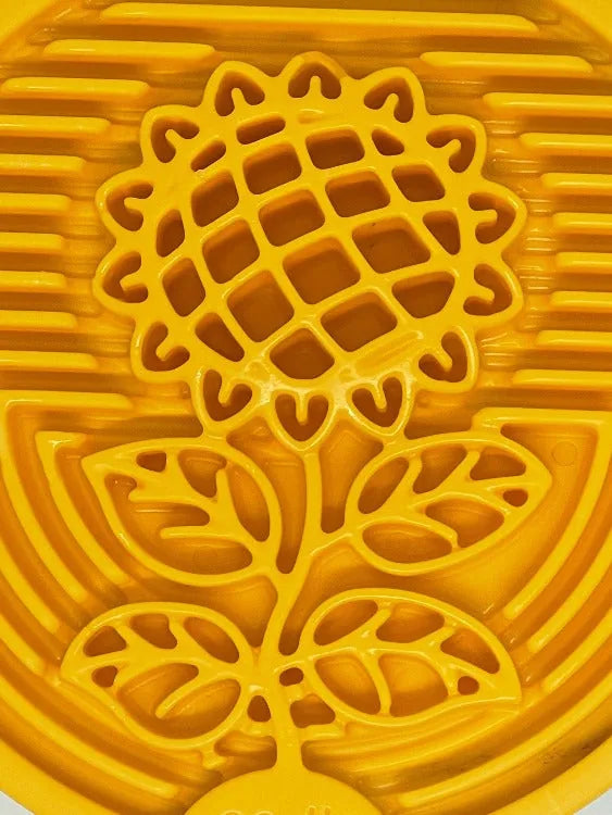 Textured yellow nylon lick mat featuring a sunflower design, ideal for helping dogs engage and reduce anxiety.