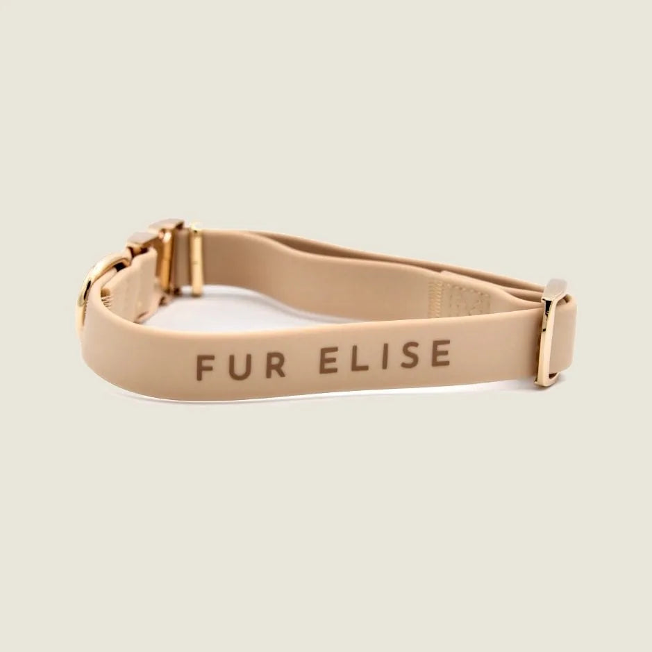 Lightweight sand-colored Elise collar with gold hardware, featuring a soft rubbery texture and "FUR ELISE" engraving.