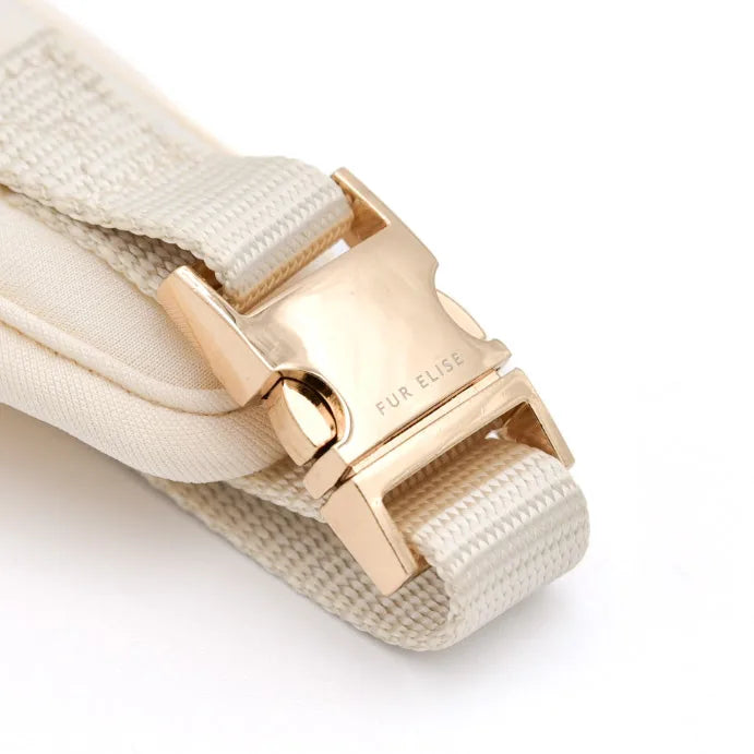 Close-up of a cream-colored harness buckle with a gold finish, part of the Elise Harness design by Elise Galleria.