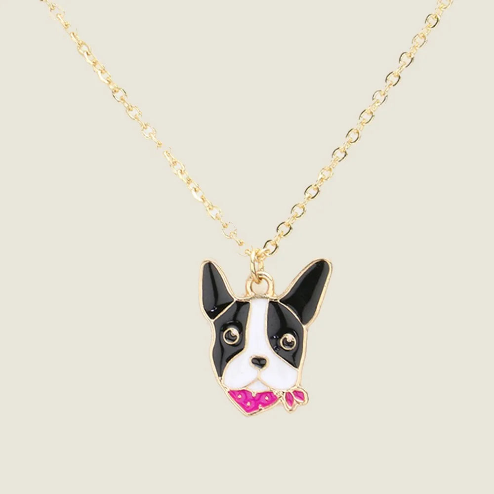 Black and white enamel French Bulldog pendant on a gold chain necklace, featuring a pink bow tie.