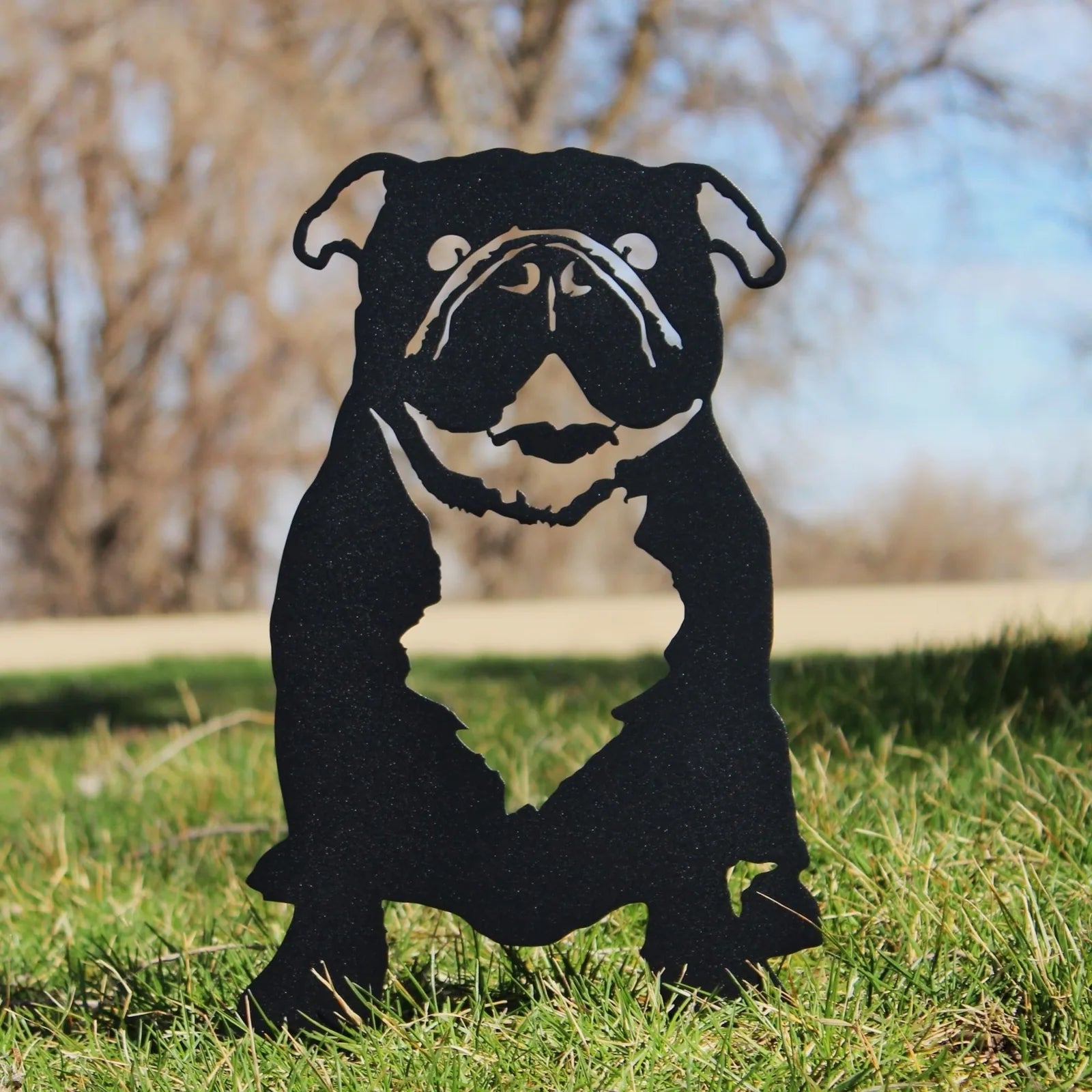 Black metal silhouette of an English Bulldog standing on grass, showcasing intricate detailing in a durable design.