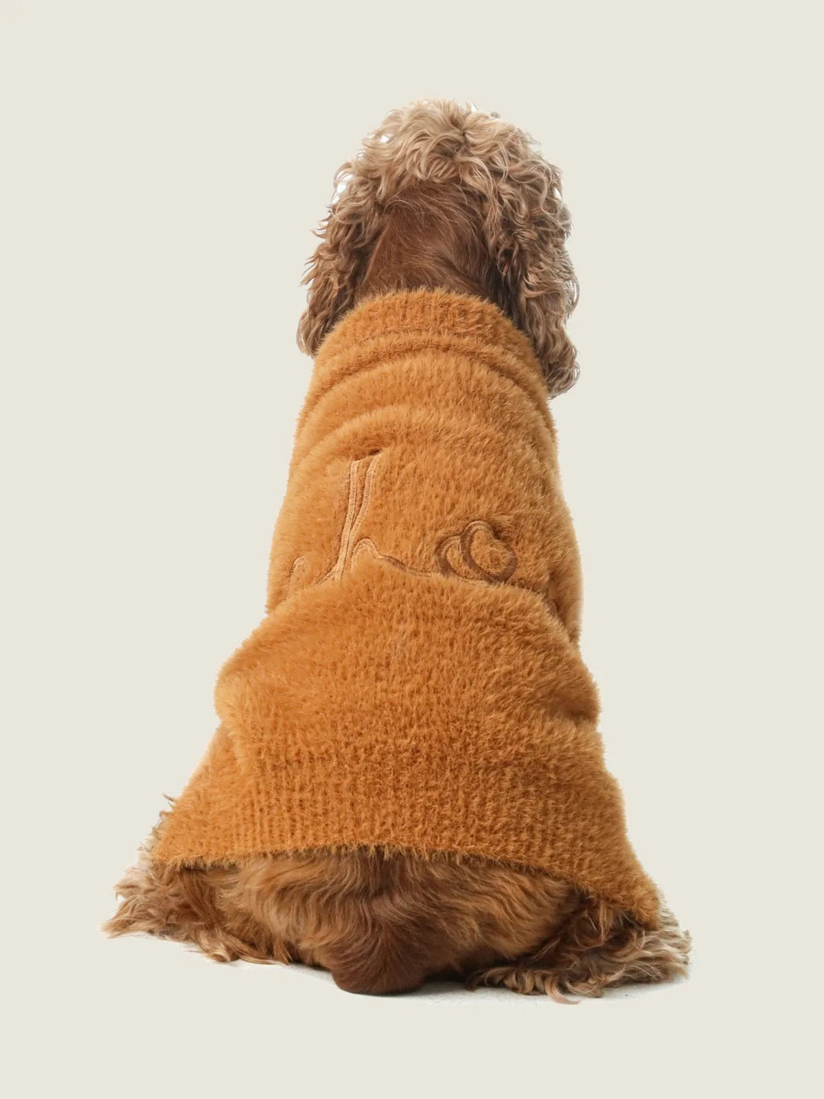 Cozy orange Eskimo fuzzy sweater on a dog, showcasing its soft texture and stretchable design for comfort.