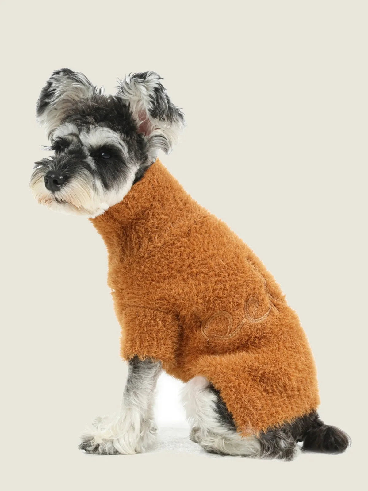 Fuzzy orange Eskimo sweater on a dog, featuring a stretchable design for comfort and warmth during chilly days.