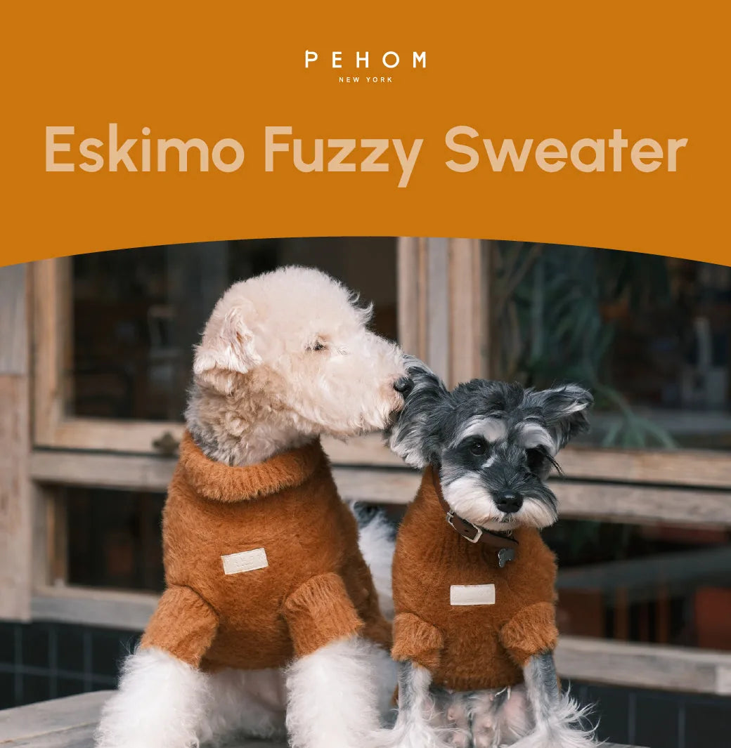 Two dogs wearing orange Eskimo Fuzzy Sweaters, showcasing a soft, fuzzy texture perfect for chilly weather.