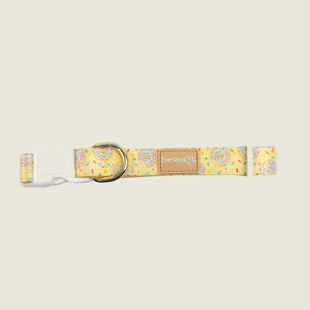 Adjustable dog collar with a yellow donut and sprinkle pattern, featuring neoprene padding and a gold D-ring.