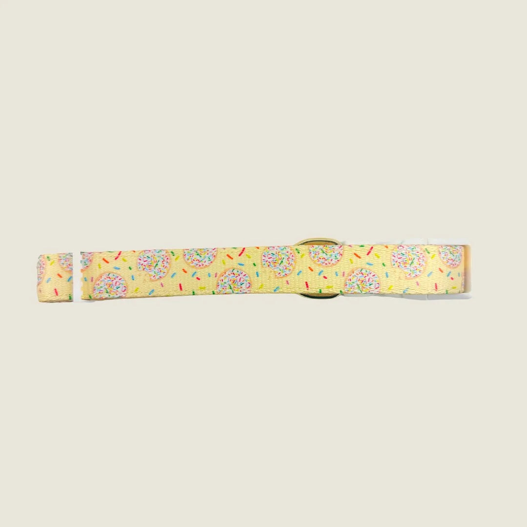 Yellow adjustable dog collar featuring a playful donut pattern with sprinkles, made from durable polyester webbing.