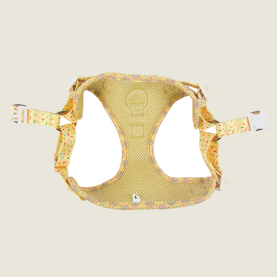 Yellow step-in dog harness featuring a playful cookie and sprinkle pattern, made with soft neoprene and breathable lining.