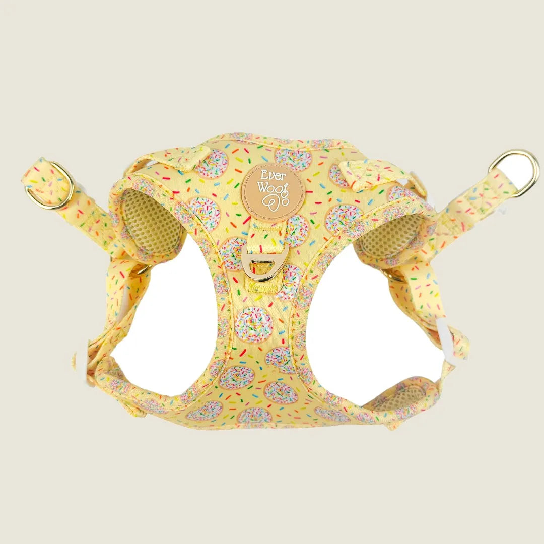 Yellow step-in harness with colorful cookie and sprinkle print, featuring soft neoprene and breathable lining.