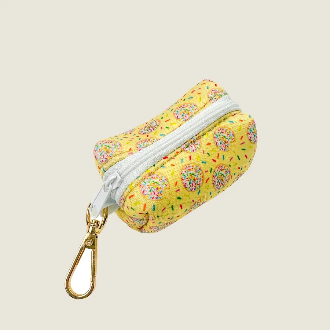 Yellow waste bag holder with donut print and white zipper, featuring a gold swivel hook for easy attachment.