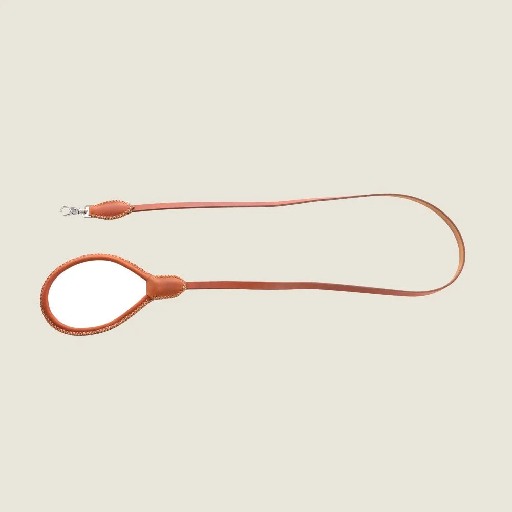 Stylish caramel leather dog leash with a flared clasp and elegant stitching, perfect for everyday walks.