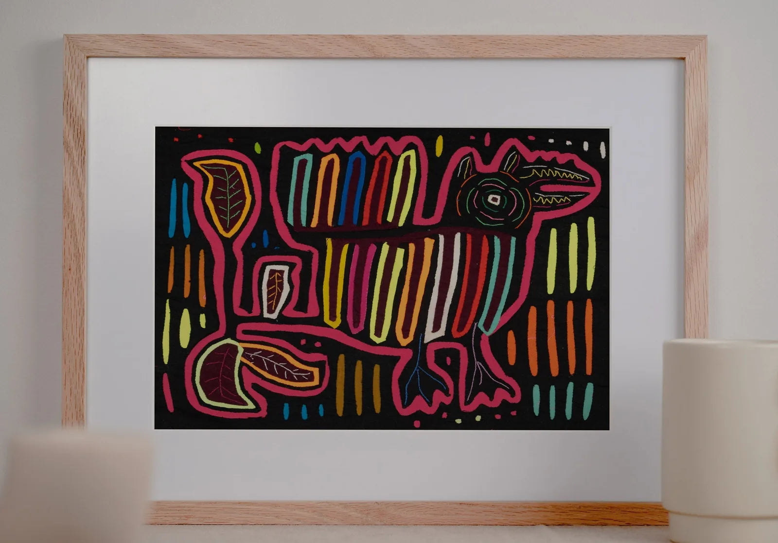 Colorful hand-stitched Mola featuring a dog design with geometric patterns on a black background.