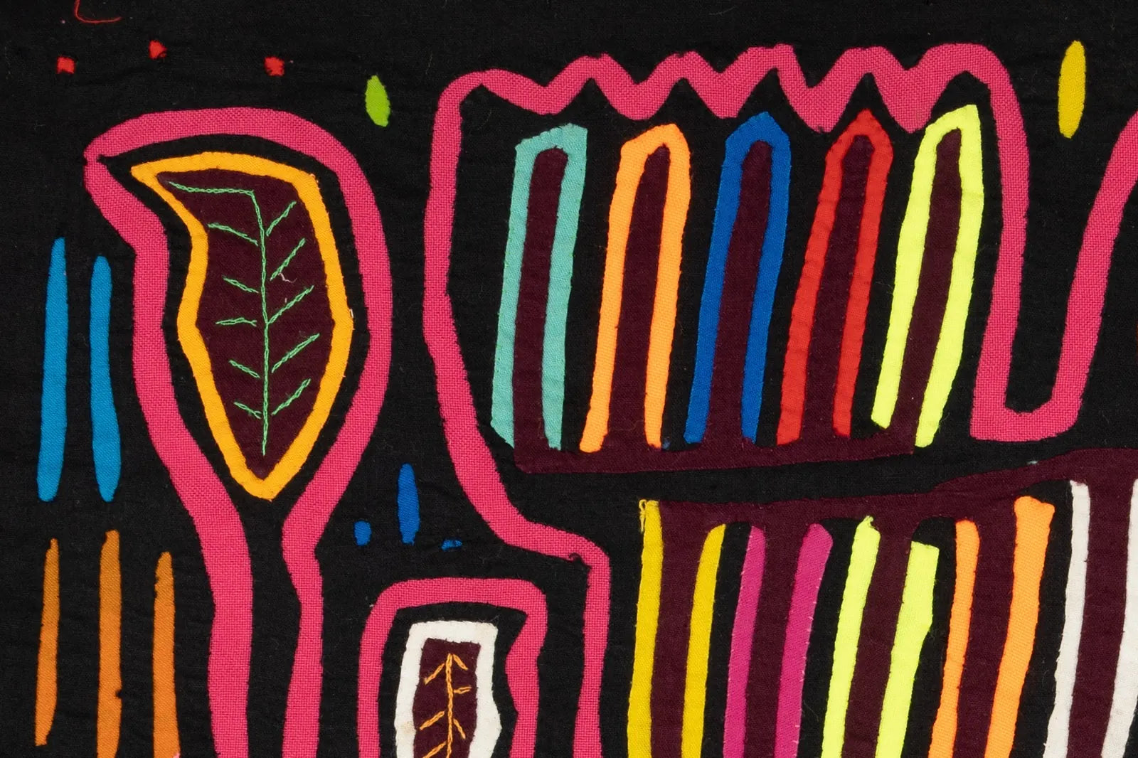 Colorful hand-stitched Mola featuring geometric shapes and leaf designs on a black background, showcasing Latin American t...