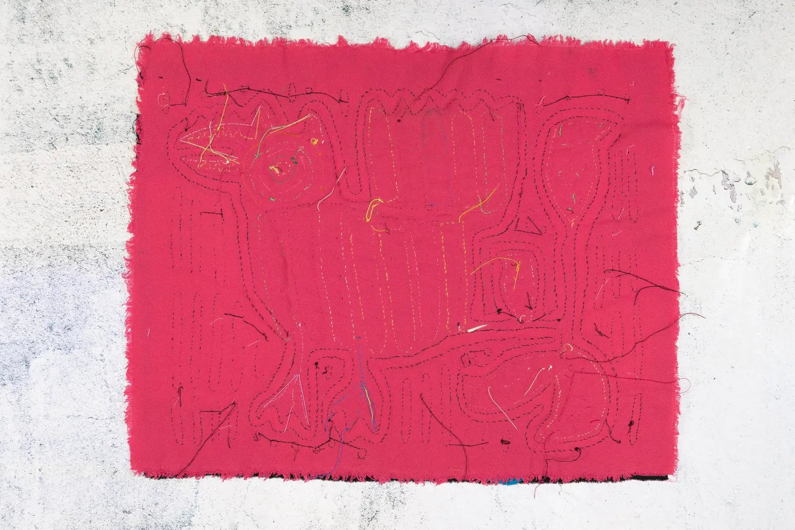 Vibrant pink handmade Mola tapestry featuring geometric patterns and textures by Guna artisans from Panama.