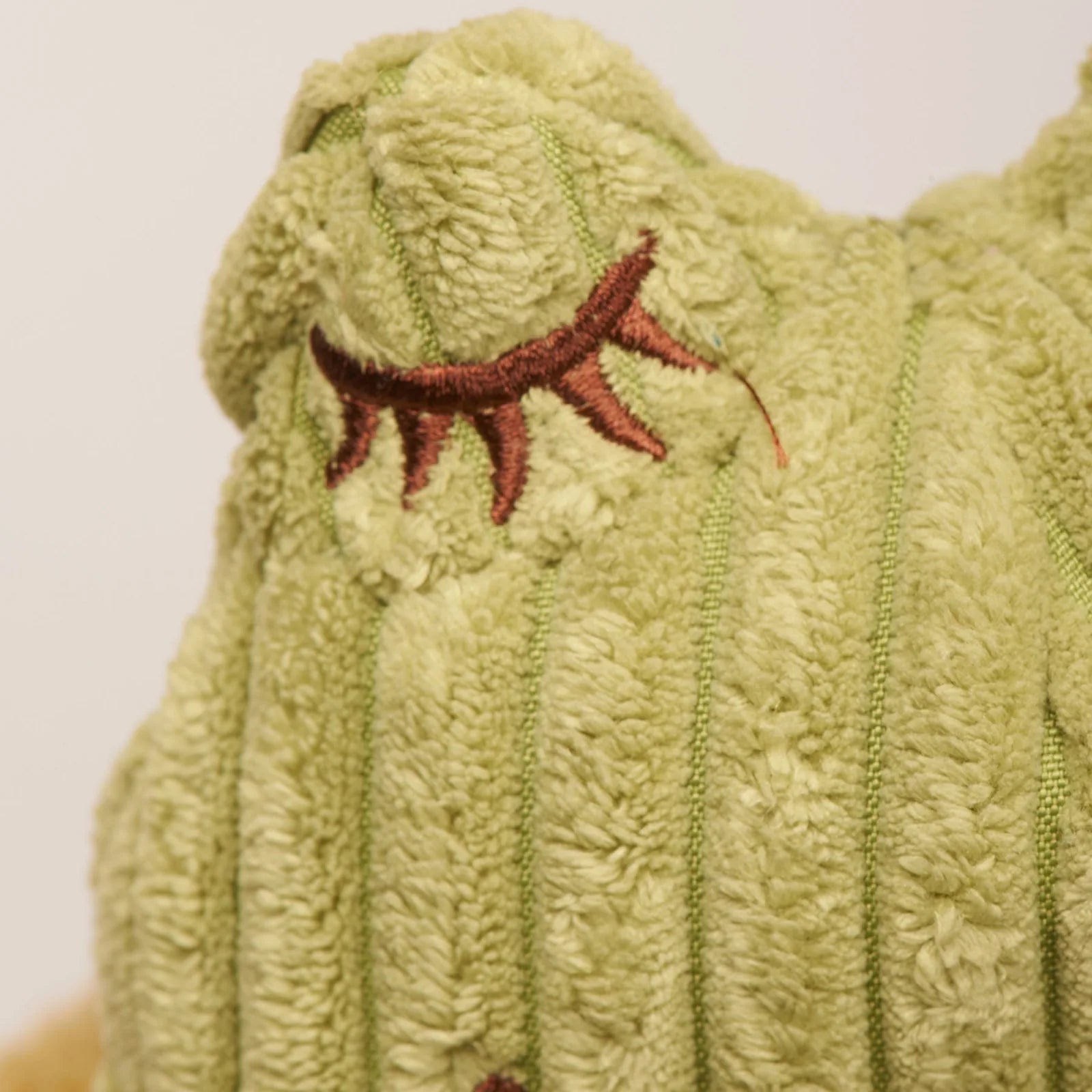 Textured green HuggleFleece® plush frog toy with embroidered details, featuring a cozy and durable design for dogs.