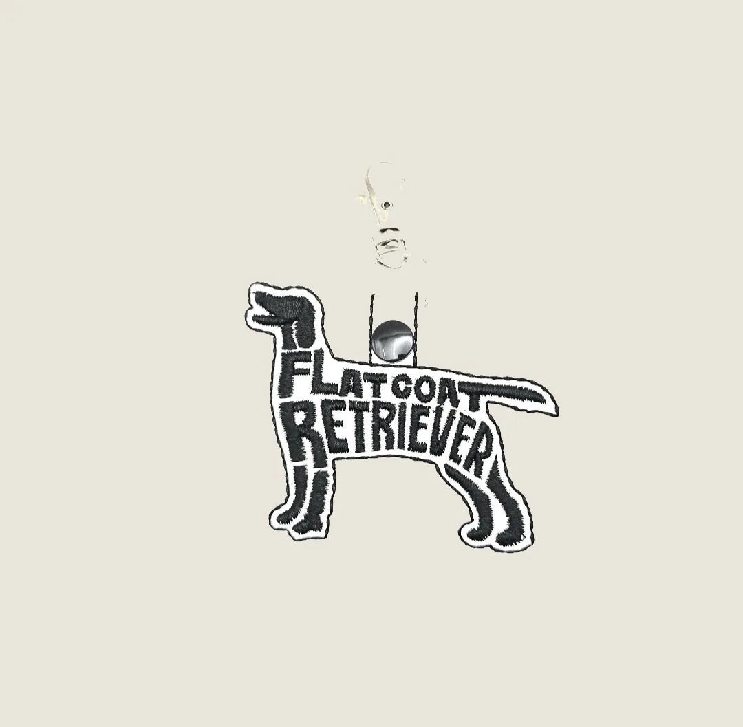 Embroidered Flat-Coated Retriever keychain in black, featuring the words "FLAT COAT RETRIEVER" in bold lettering.