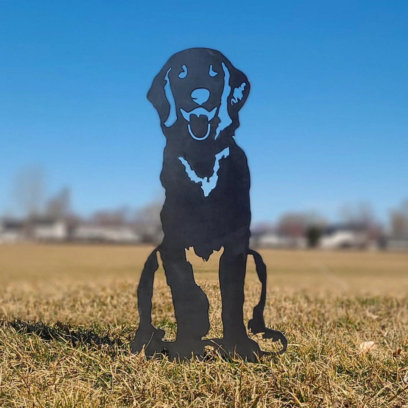 Handcrafted black metal silhouette of a Flat-Coated Retriever, set against a clear blue sky, ideal for garden decor.