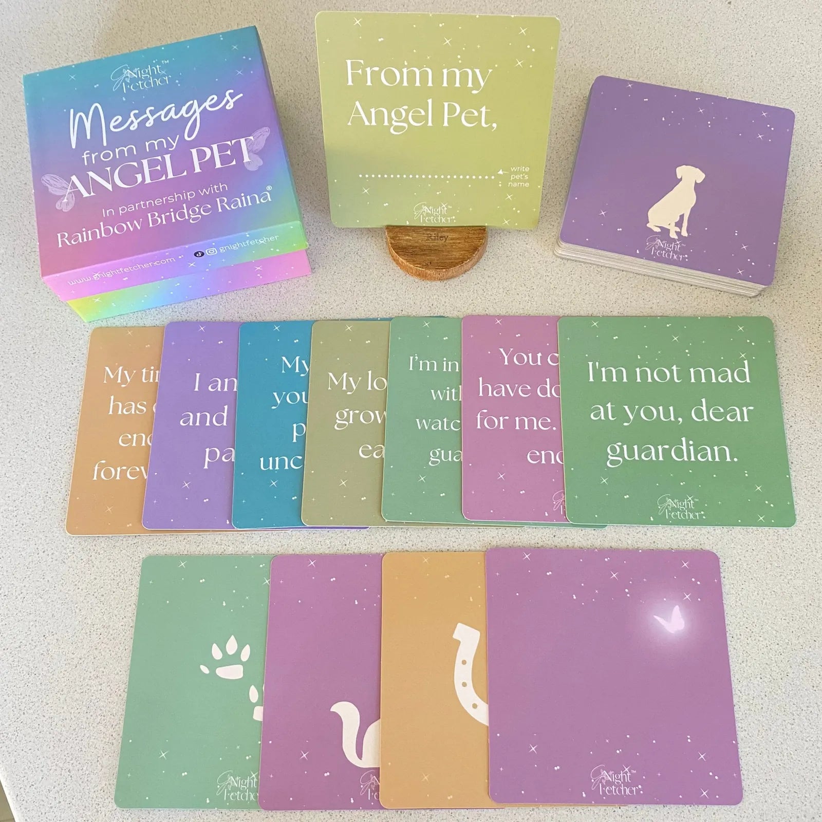 Colorful comfort cards featuring affirmations and messages for children coping with pet loss, alongside a decorative stand.