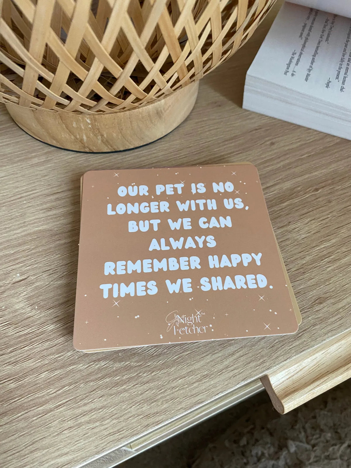 Affirmation card with a warm beige background, featuring comforting text about pet loss, placed on a wooden surface.