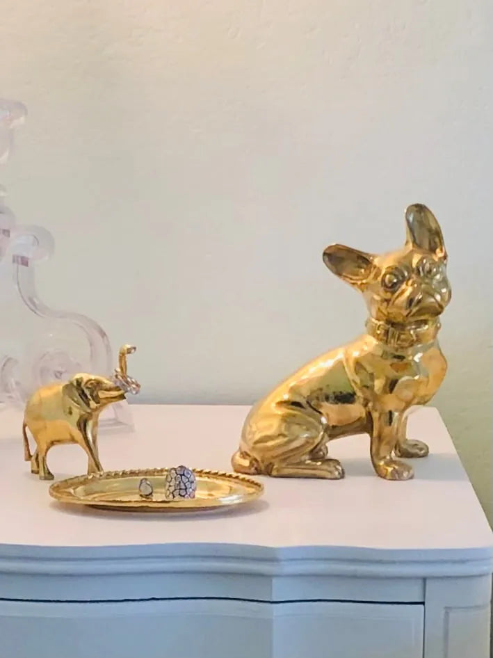 Handcrafted brass French Bulldog sculpture with a glossy finish, displayed beside a small elephant figurine.