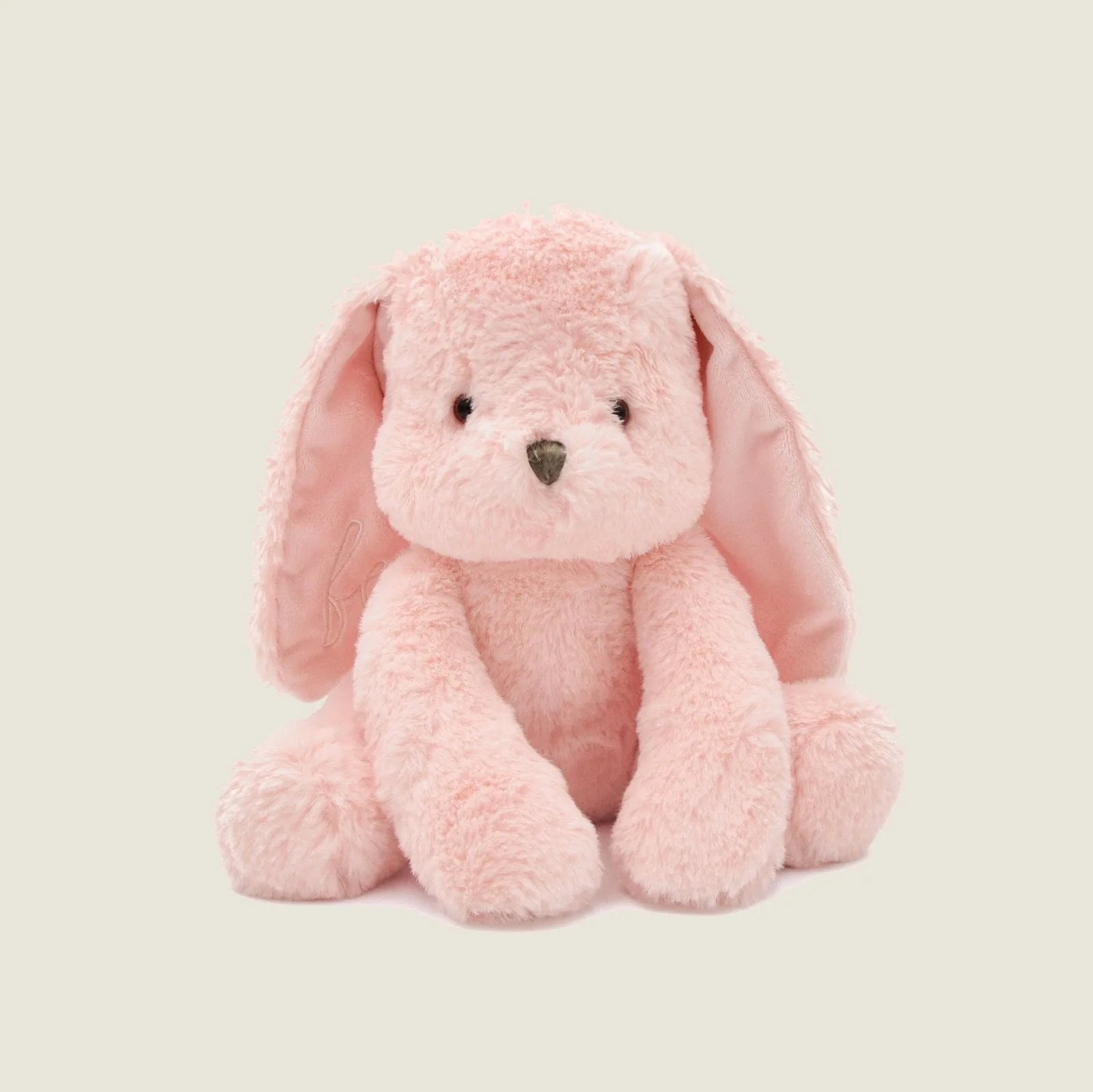 Soft pink plush rabbit toy with long floppy ears, hand-stitched eyes, perfect for gentle play and cuddling.