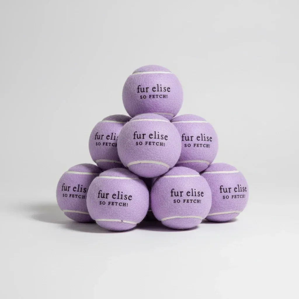 Lilac tennis balls stacked in a pyramid with "fur elise SO FETCH!" printed, perfect for dog playtime.