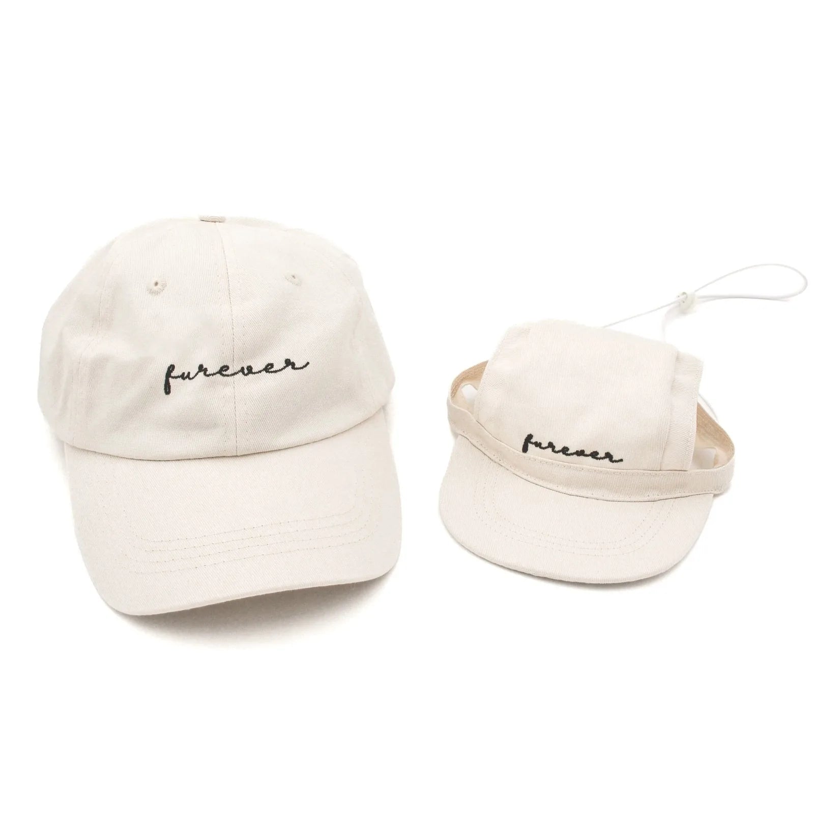Matching beige baseball hats for dogs and humans, featuring an embroidered "furever" design in cursive.