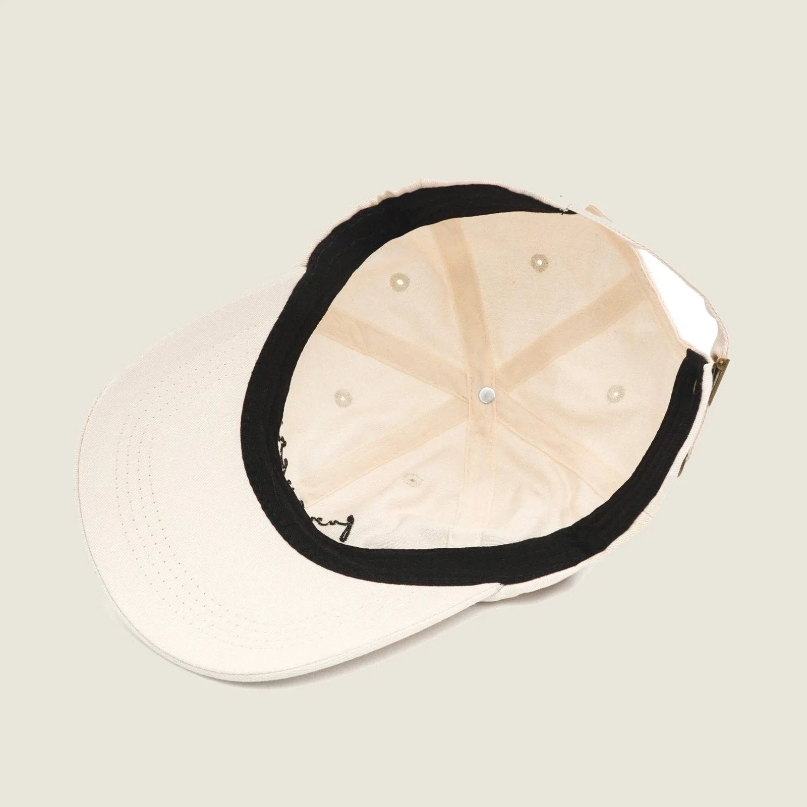Interior view of the Furever Human Hat, featuring a light cotton fabric in off-white with a black lining.