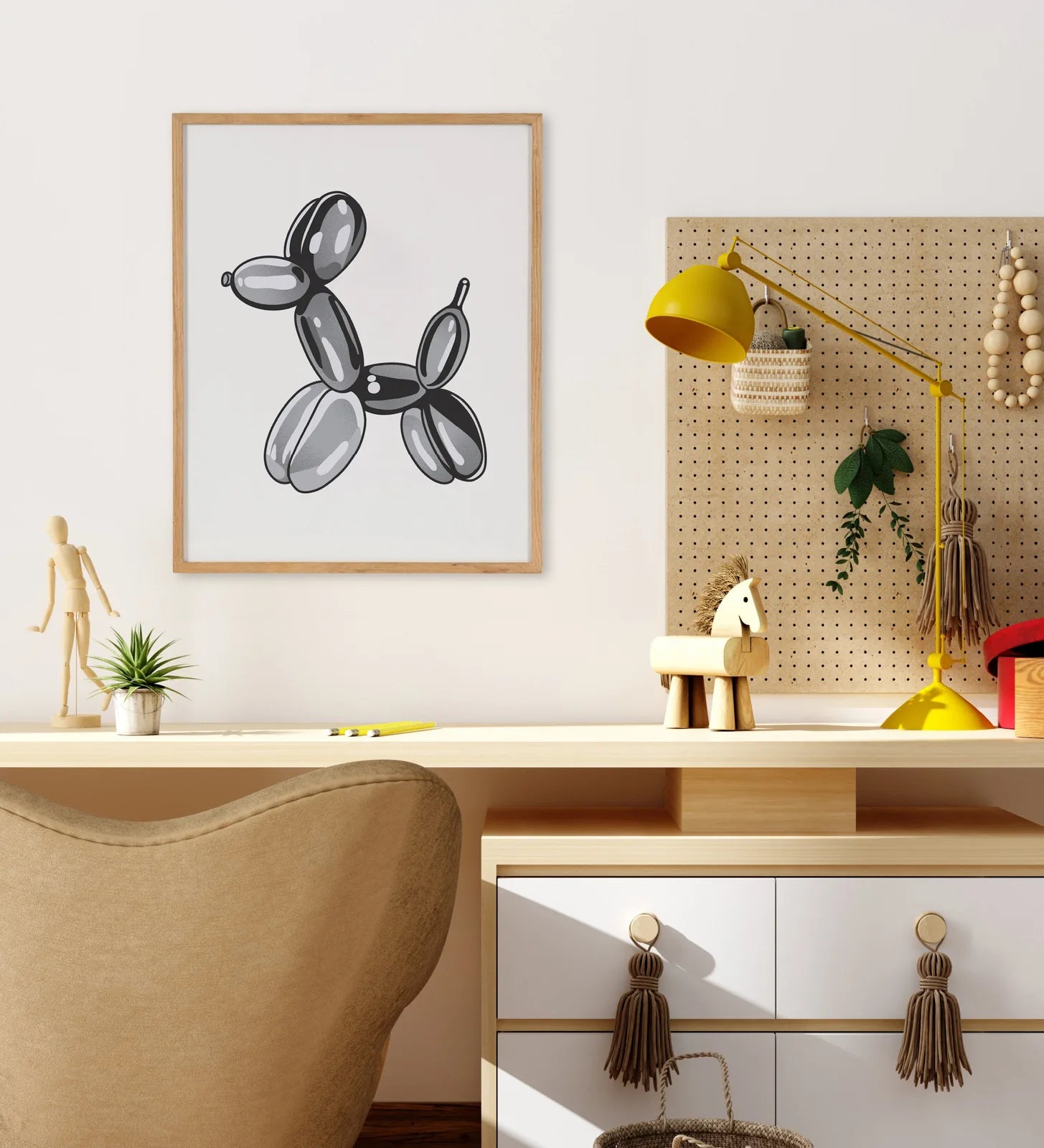 Framed art featuring a playful black balloon dog design with a natural wood frame, displayed in a stylish home office.