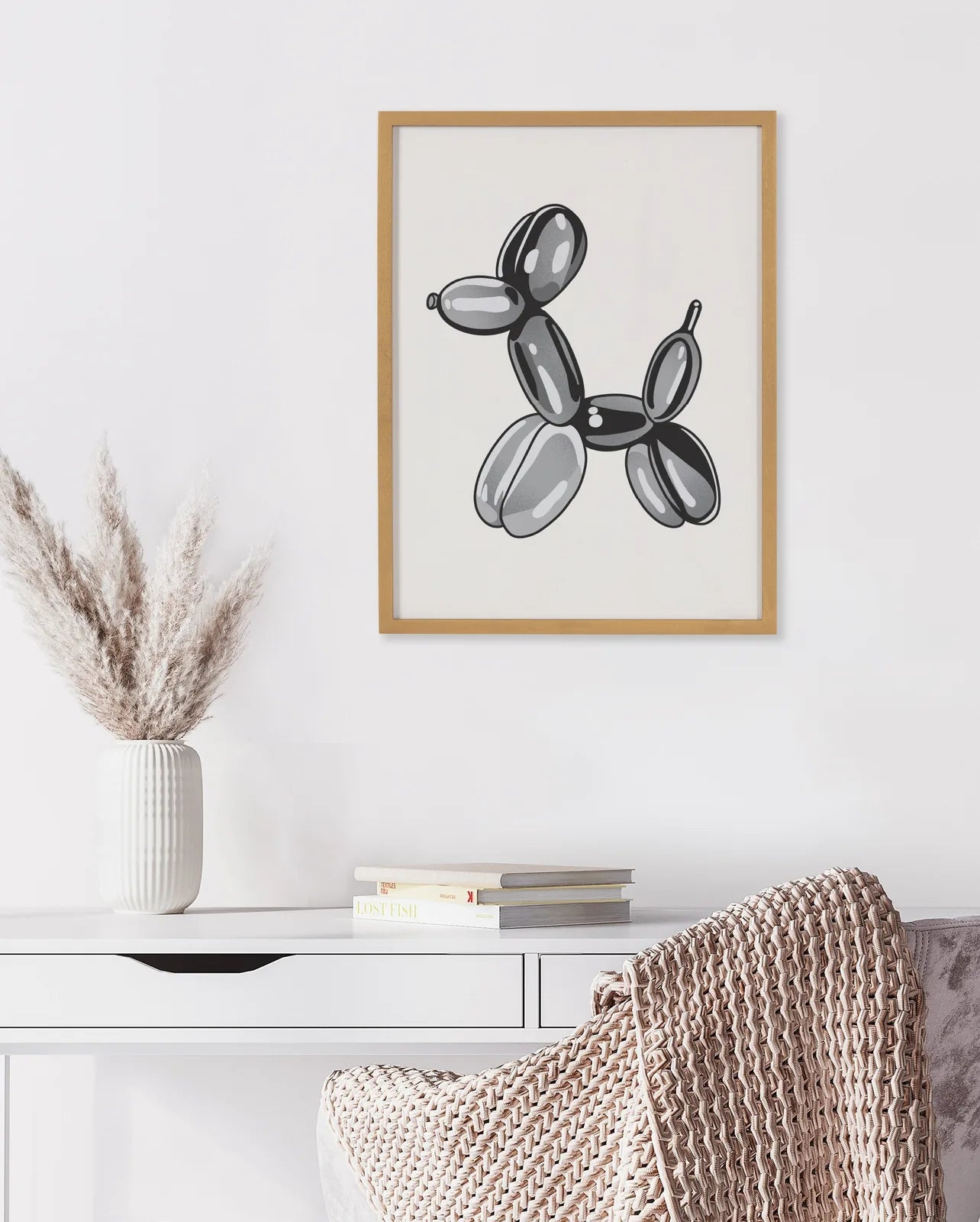 Framed black balloon dog art print in a simple gold frame, complementing a modern home decor style.
