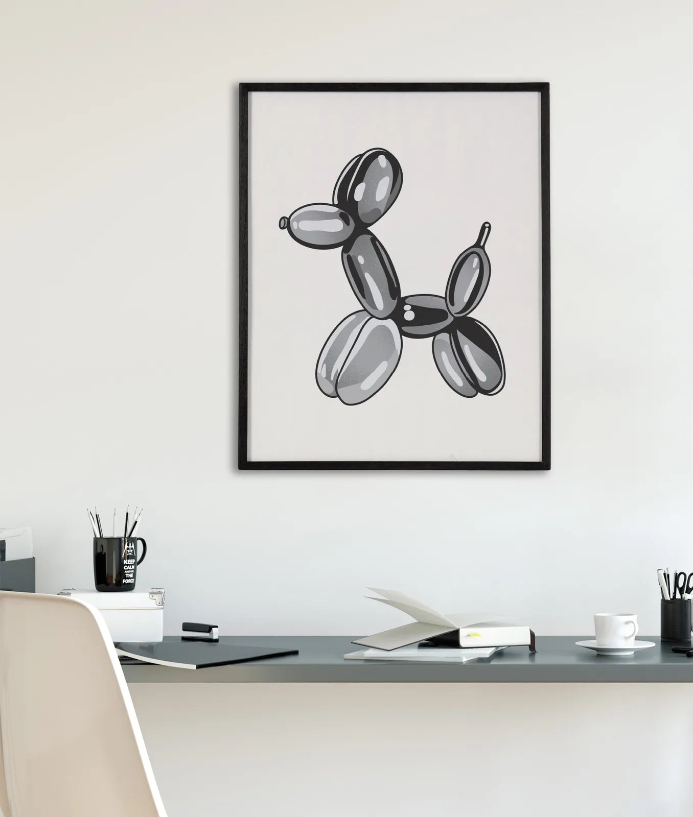 Framed black and white balloon dog art hanging in a modern workspace, complementing the minimalist decor.
