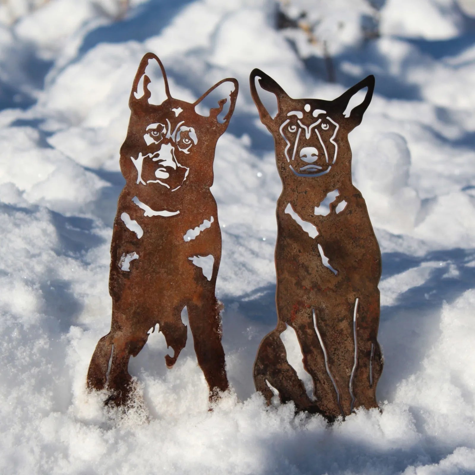 Rusty metal silhouettes of two German Shepherds standing in snow, showcasing intricate cut-out details and sturdy design.