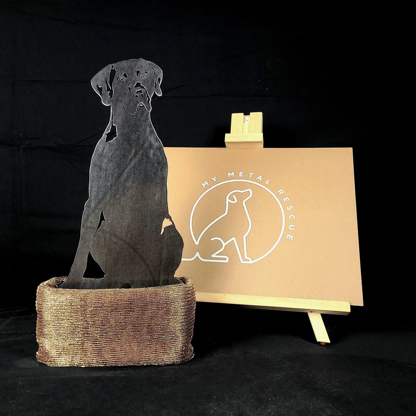 German Shorthaired Pointer metal silhouette in black, displayed in a textured bronze base with a brand sign behind it.