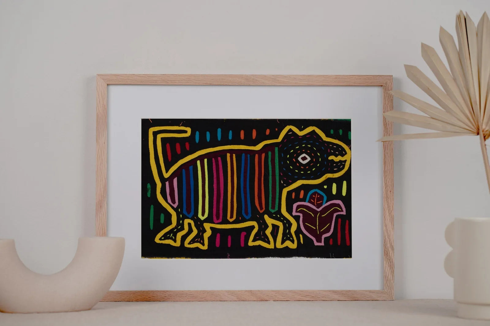 Colorful Mola tapestry featuring a golden retriever puppy, hand-stitched with geometric patterns on a black background.