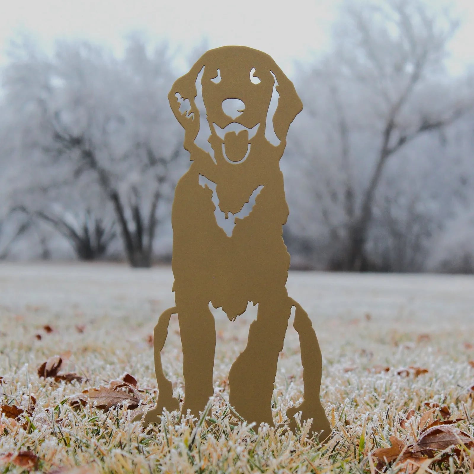 Handcrafted Golden Retriever silhouette in gold metal, surrounded by frosty grass and autumn leaves, ideal for outdoor decor.