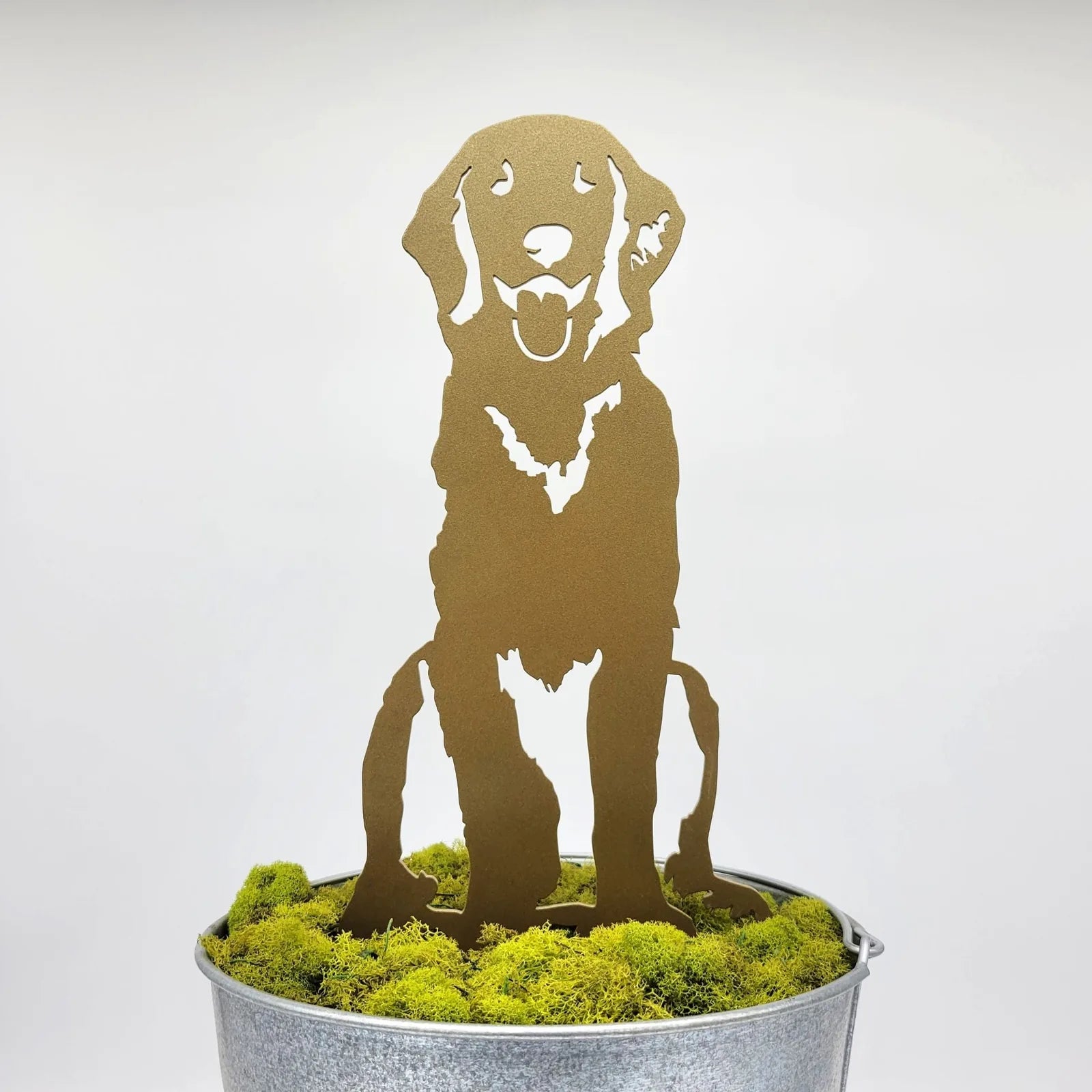 Golden Retriever sitting silhouette in shiny gold metal, displayed in a galvanized pot with green moss, ideal for home décor.