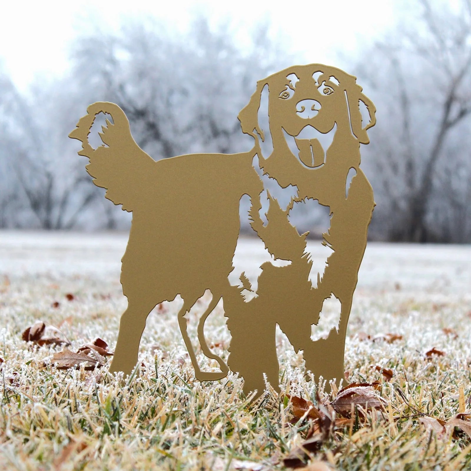 Golden Retriever metal silhouette in gold, standing on frosty grass, with intricate cut-out details.