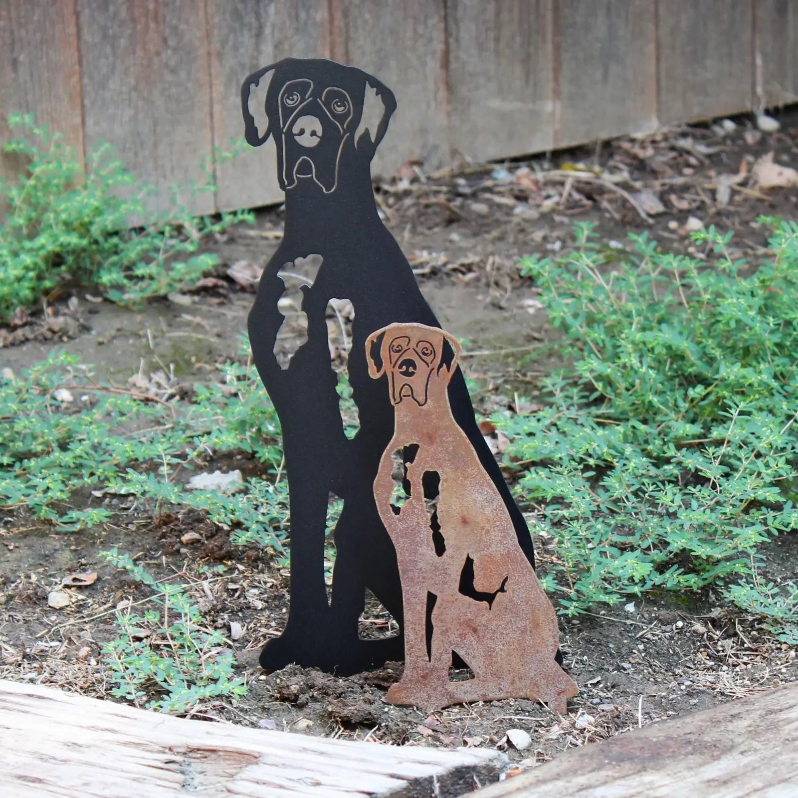 Great Dane silhouette garden decor in black and rust Corten steel, displayed among greenery.