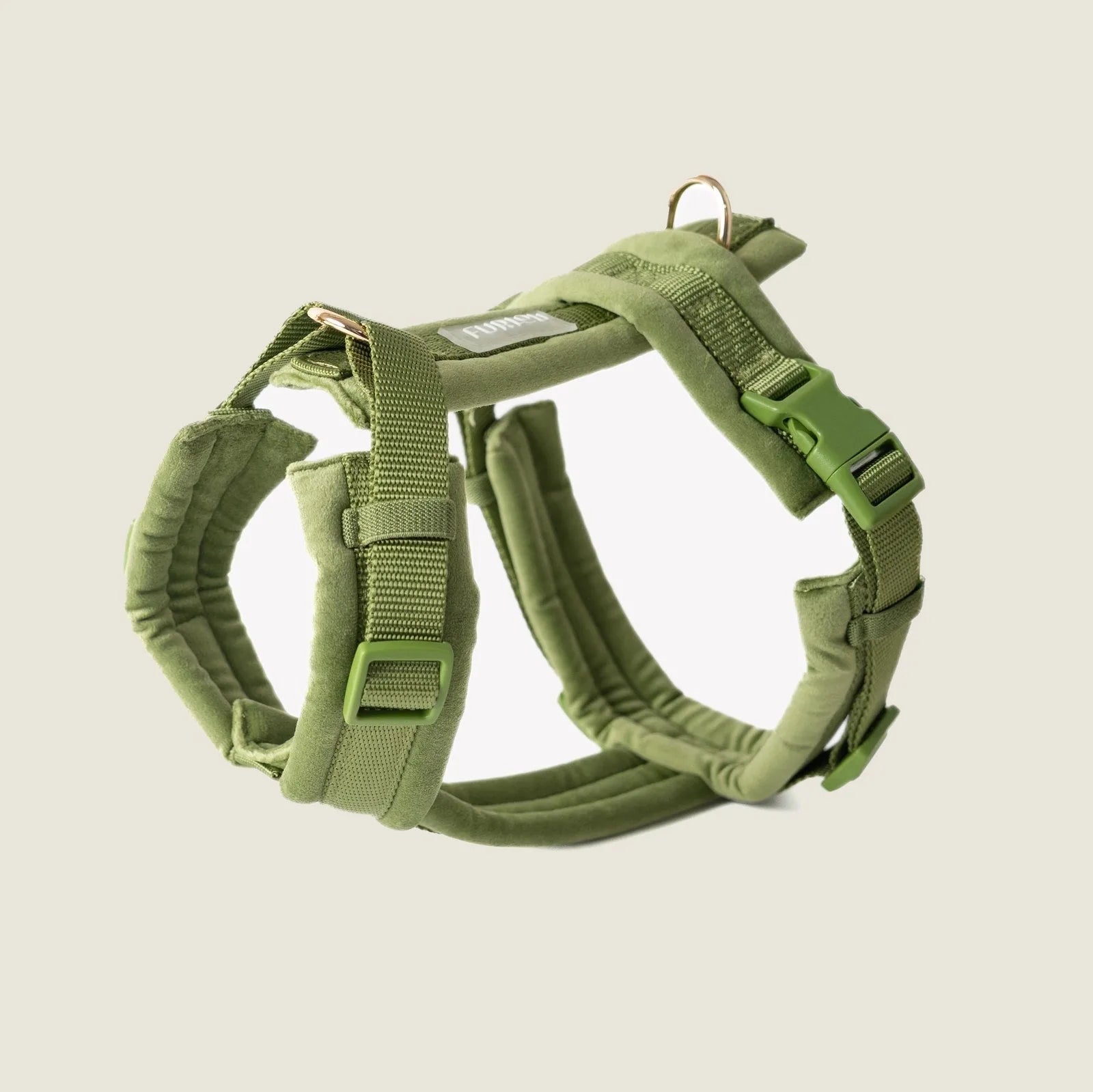 Green velvet dog harness featuring adjustable straps and padded lining for comfort, ideal for walks and outings.
